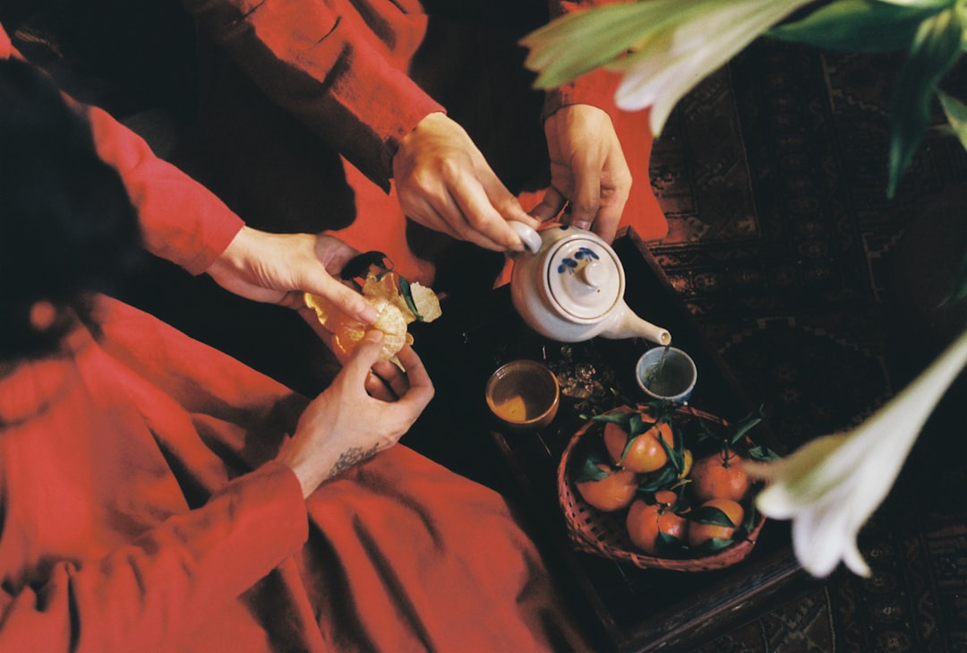 a woman in a red dress is pouring tea