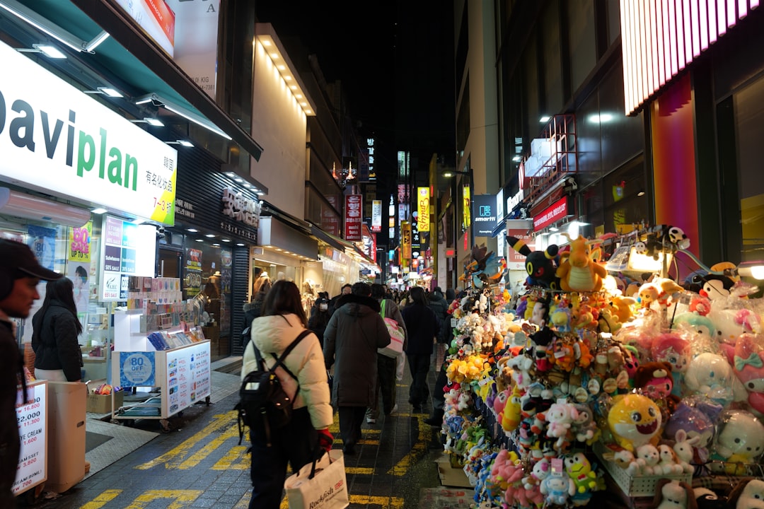 Crowded street market at night with many stalls and people.