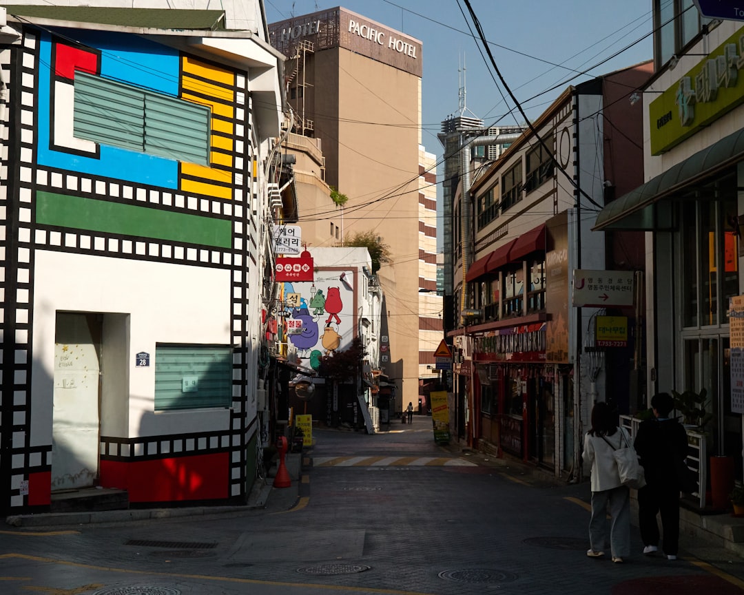 a couple of people walking down a street next to a tall building