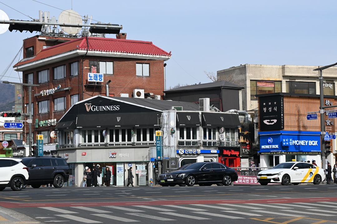 Street view of buildings and cars on a sunny day.