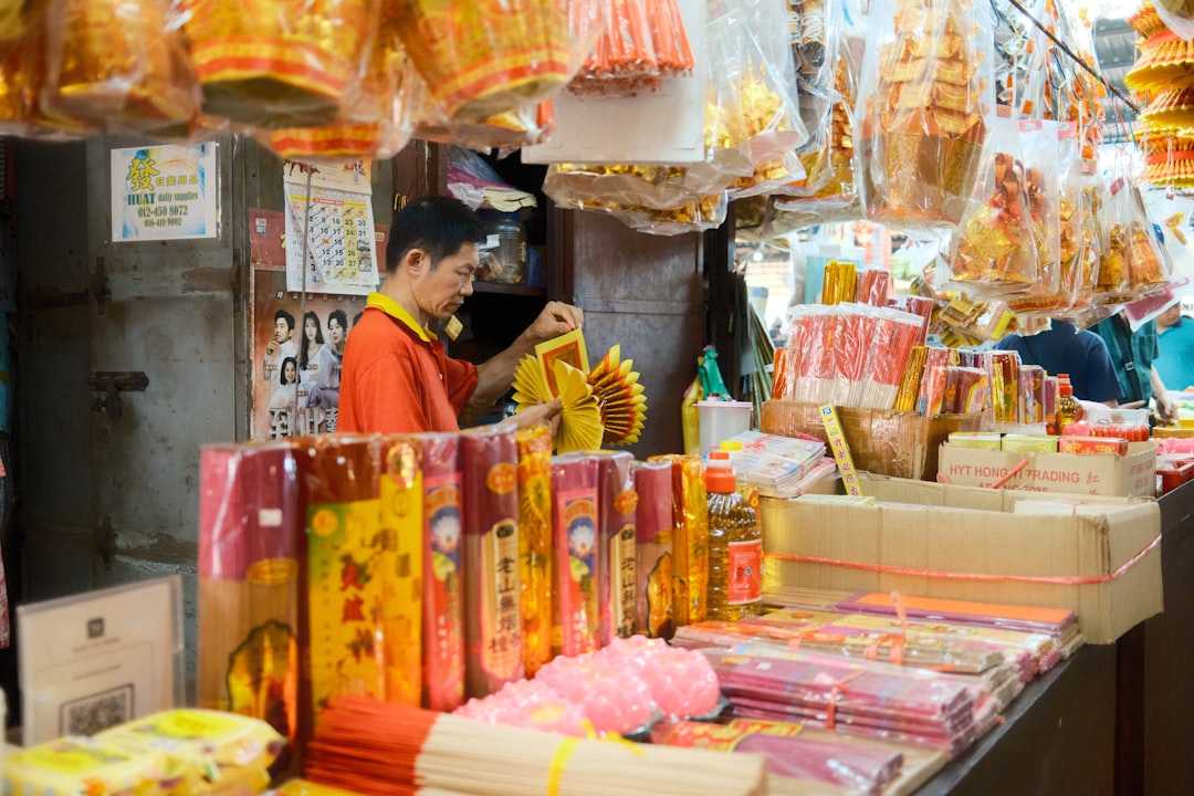A man standing in front of a store filled with packaged goods