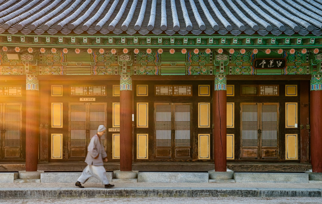 woman in white dress standing near brown wooden door