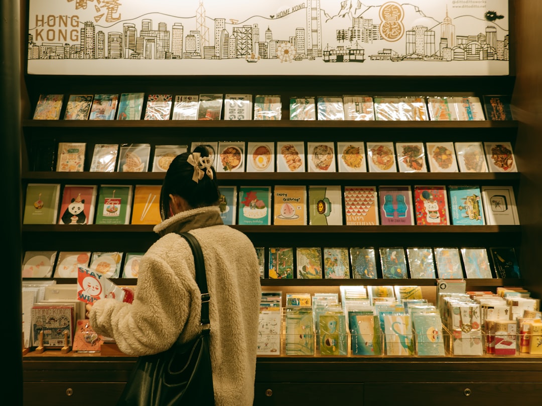 A woman browses postcards in a gift shop.