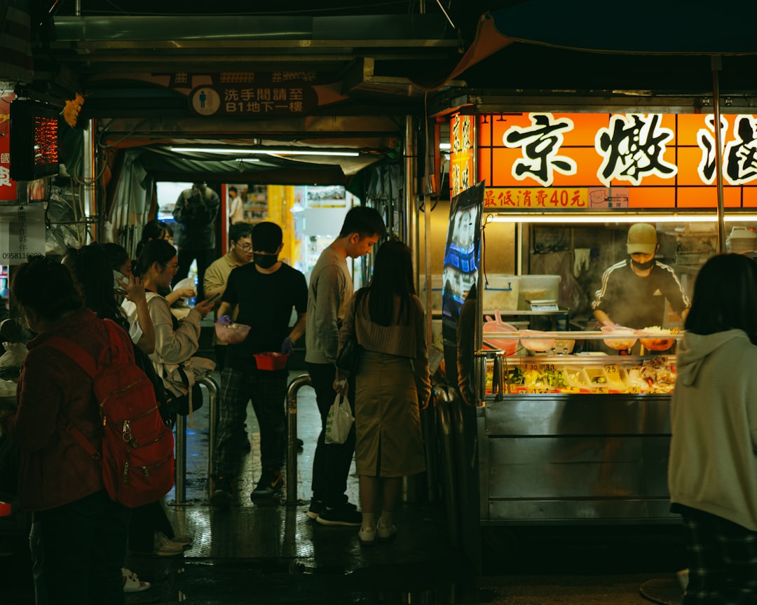 People gather at a street food stall at night.