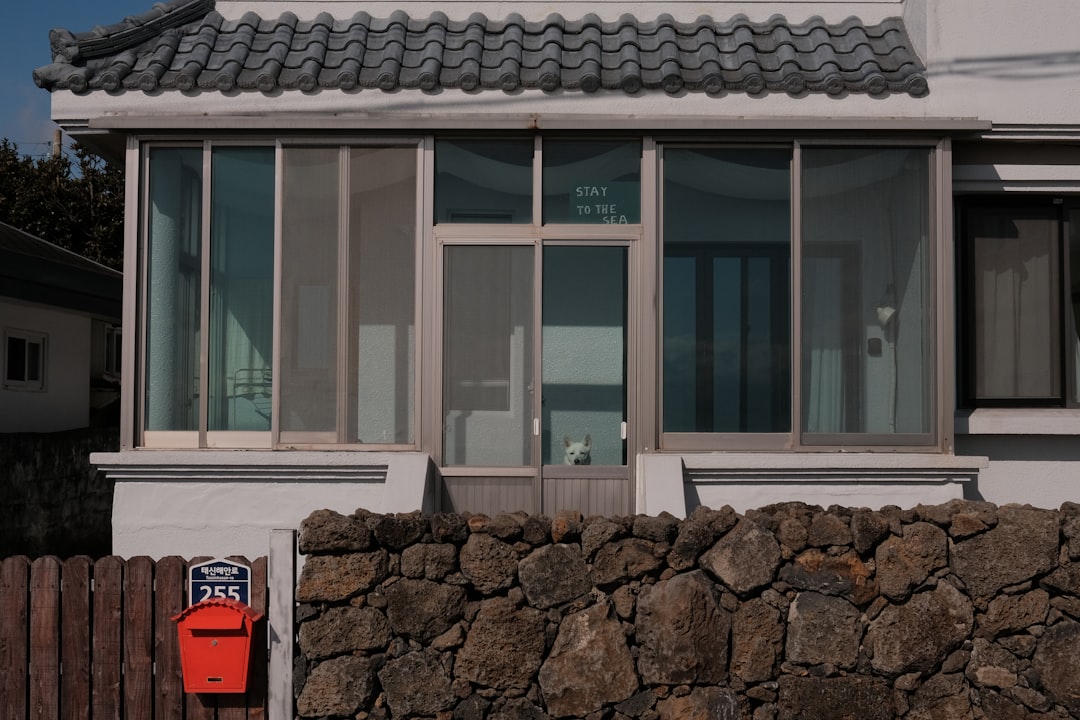 A red mailbox on a stone wall outside house