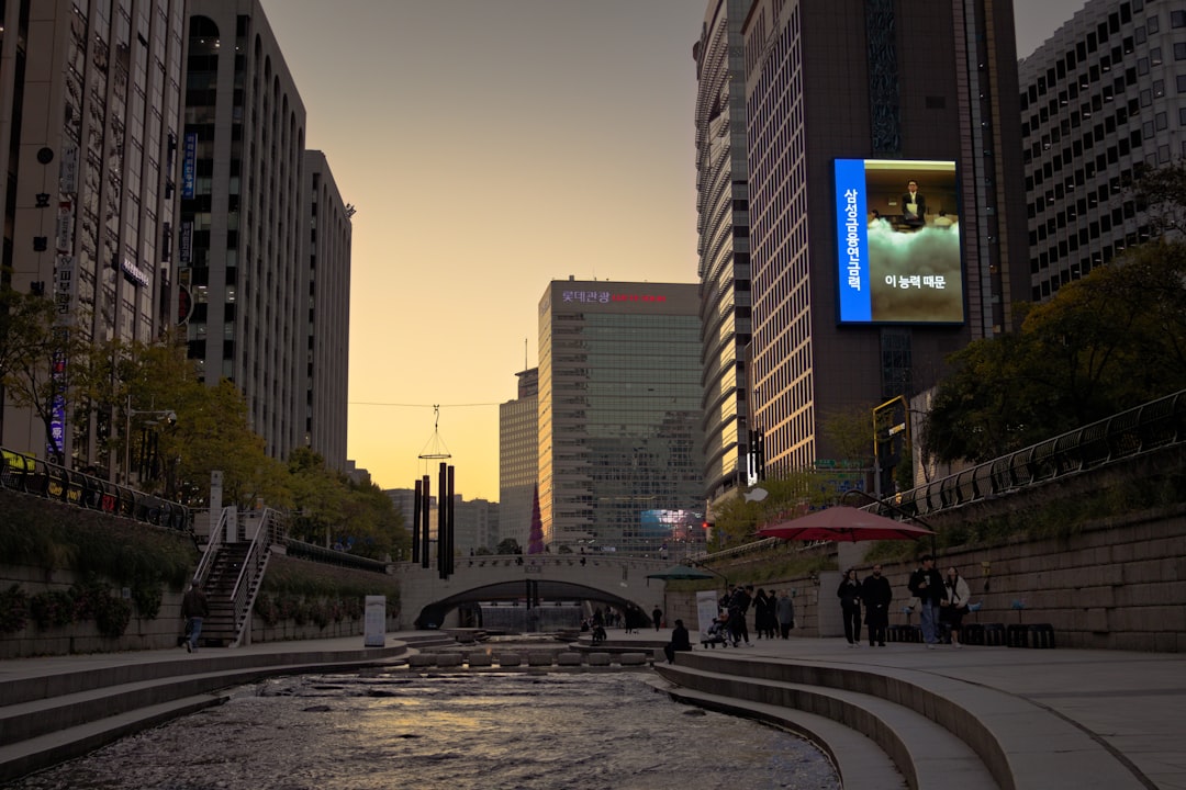Cityscape with a river and bridge at sunset.