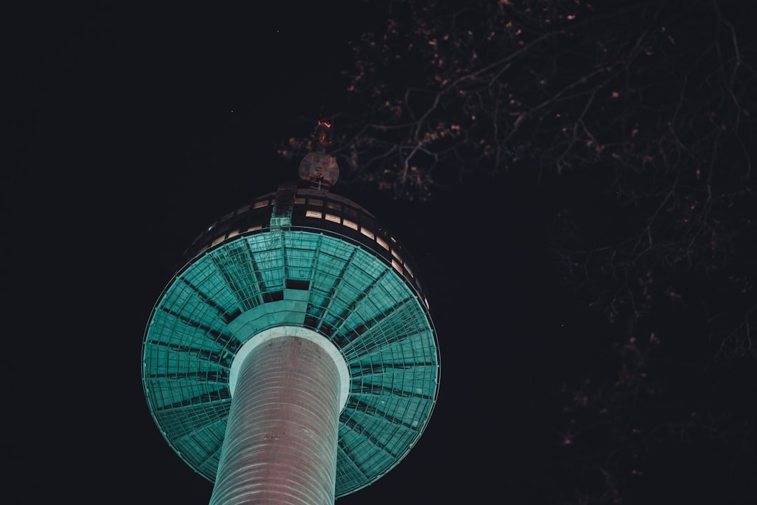 the top of a tall tower lit up at night