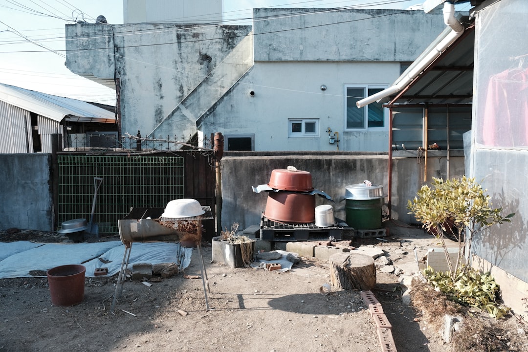 Backyard with stacked barrels and various items.