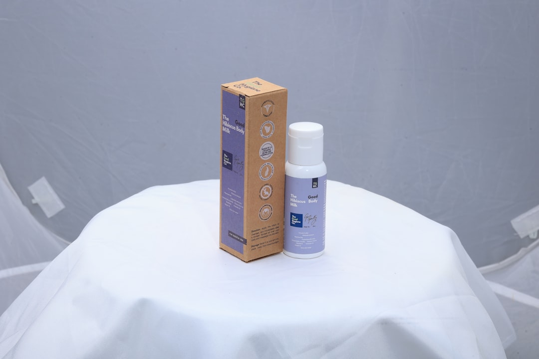 A small bottle and box on a white surface.