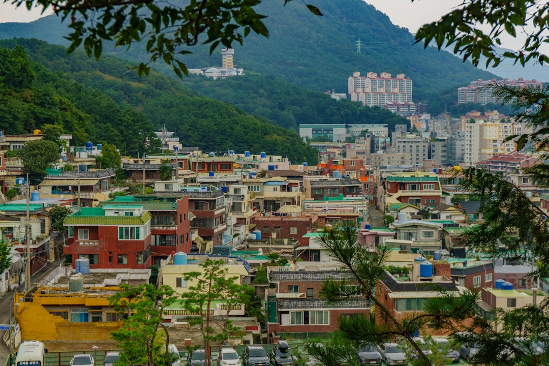 Colorful buildings nestled on a hillside with mountains.