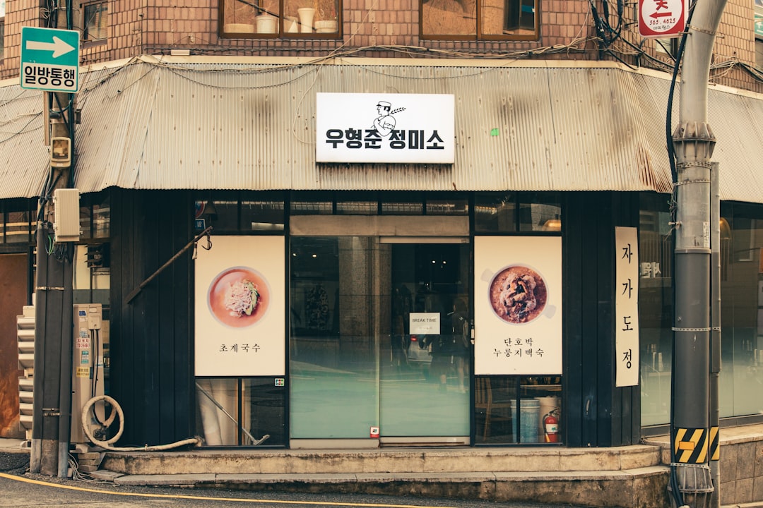 A storefront with korean text and circular posters.