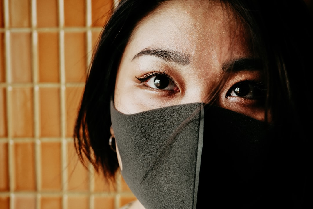 woman covering face with black textile