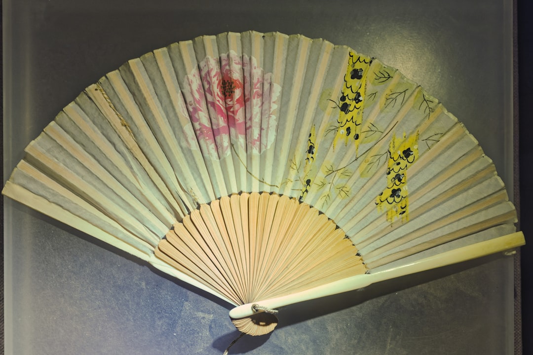 A delicate folding fan with floral designs.
