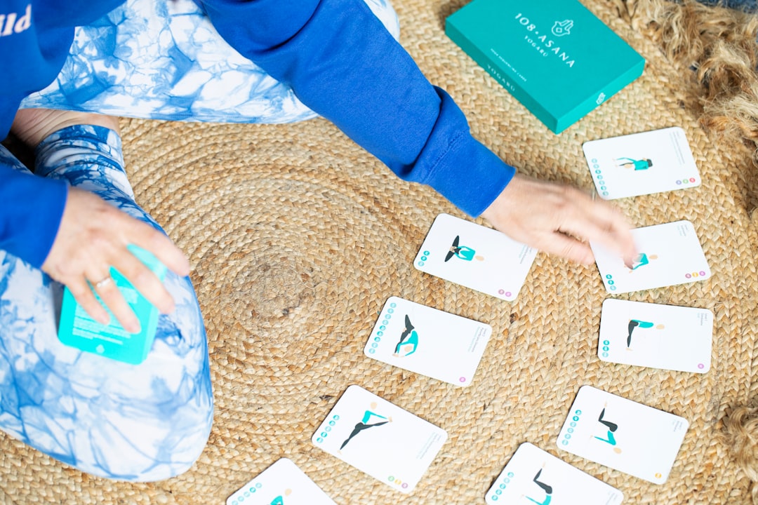 Person arranging yoga pose cards on a rug