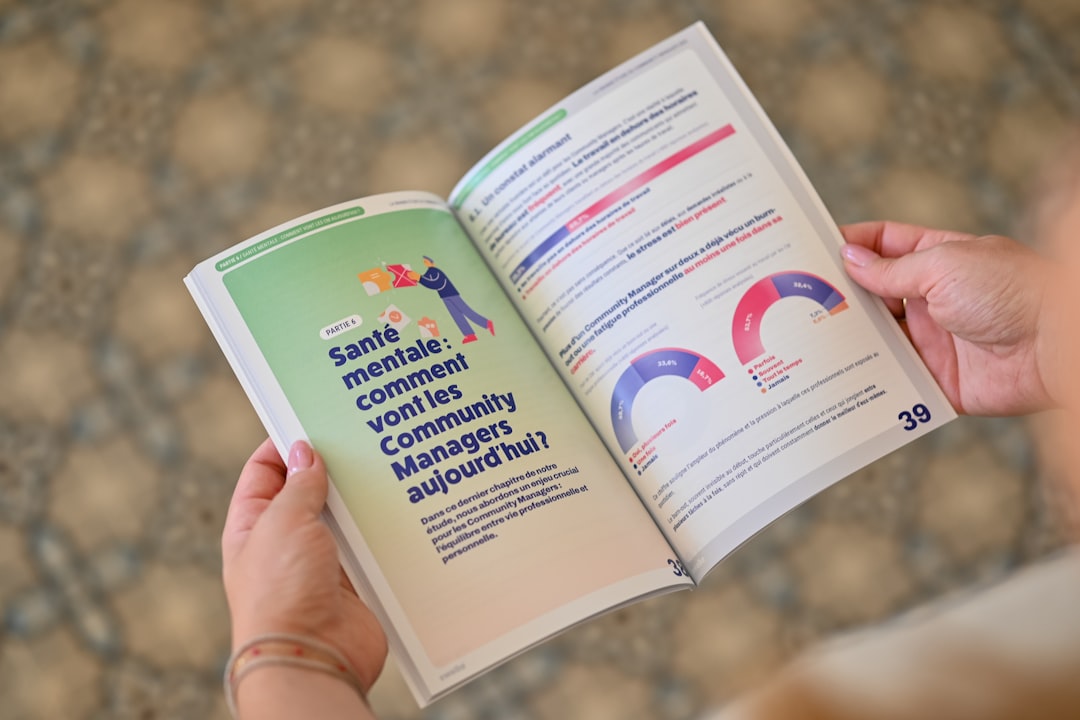 Person holding an open booklet with text and charts.