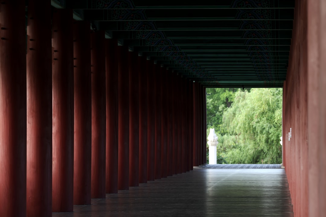 A long hallway lined with red columns and trees