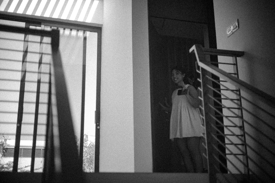 A woman stands on a staircase near a doorway.