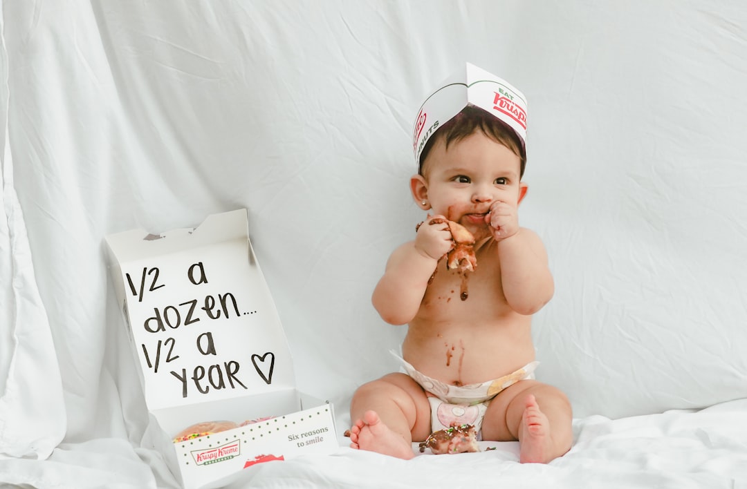 Baby eating donuts with a half birthday box