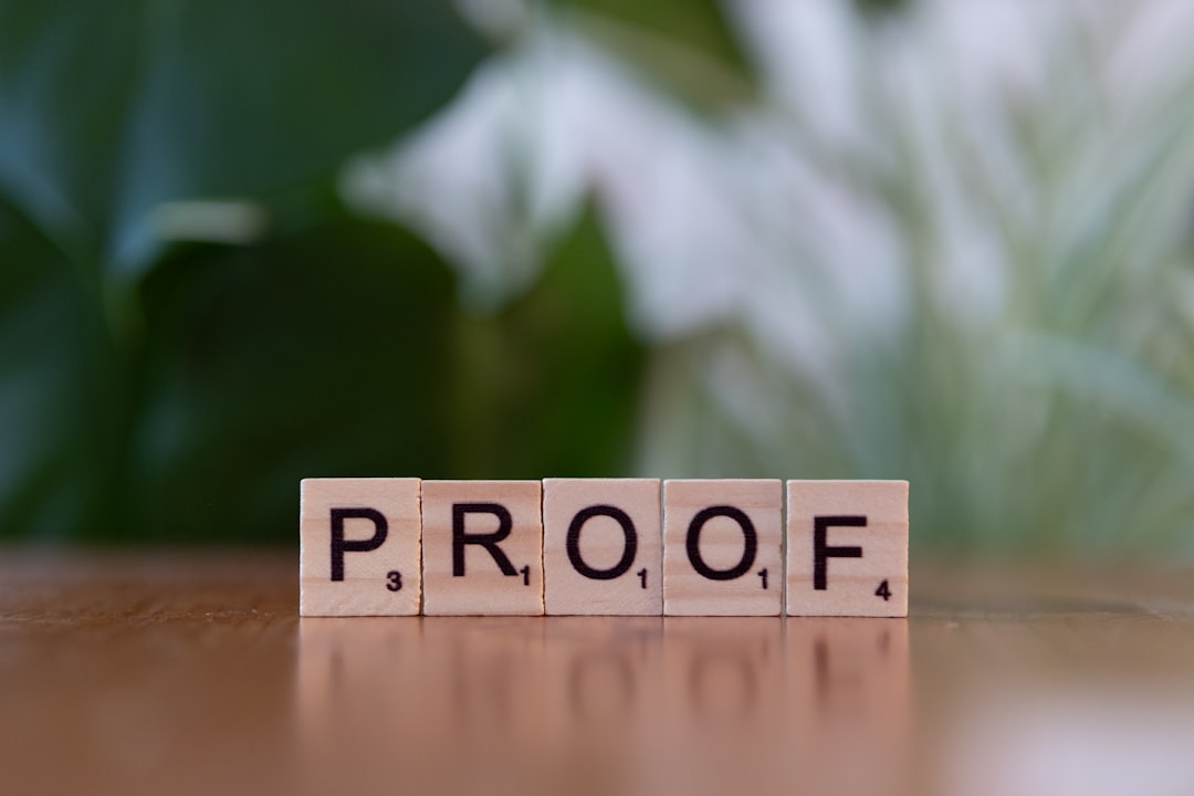 A wooden block spelling proof on top of a table