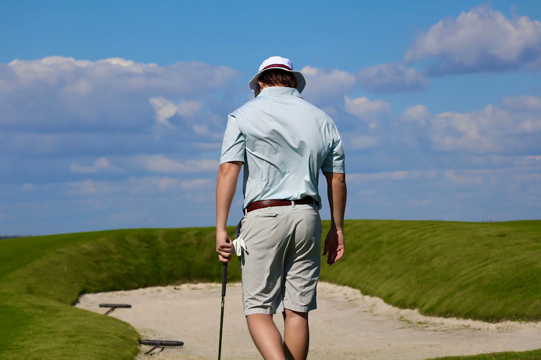 A man walking on a path with a golf club